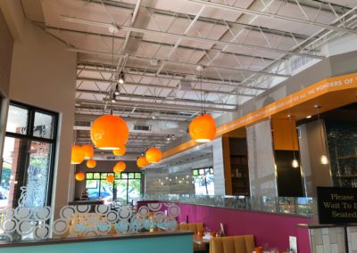 Tangerine Breakfast Restaurant interior with white acoustic panel treatment on white industrial ceiling well lit room