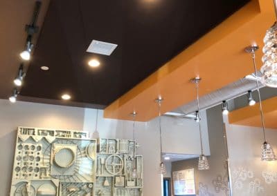 Tangerine Breakfast Restaurant interior with dark brown acoustic panel treatment stretched fabric integrated lighting over bar