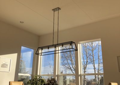 Home Interior with acoustic treatment stretched fabric on ceiling above dining room table with integrated lighting