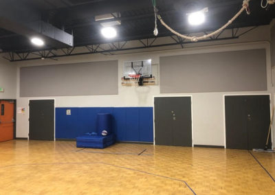 Friends School gym interior with gray stretched fabric acoustic treatment insulation panel wall
