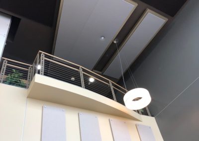 Large interior wall natural light with acoustic treatment panels stand off mounted to wall gray with metal fixtures above stairwell